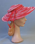 A vintage red and white ombre woven sun hat with red ribbon ties