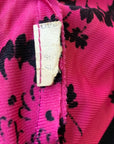 closeup view of maker's tag remnant on 40s pink print top