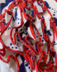 close up of red edging, ruffles on bust