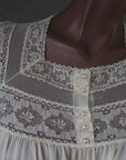 close up detail, net and lace bodice trim with pearl buttons, cream colored nylon nightgown
