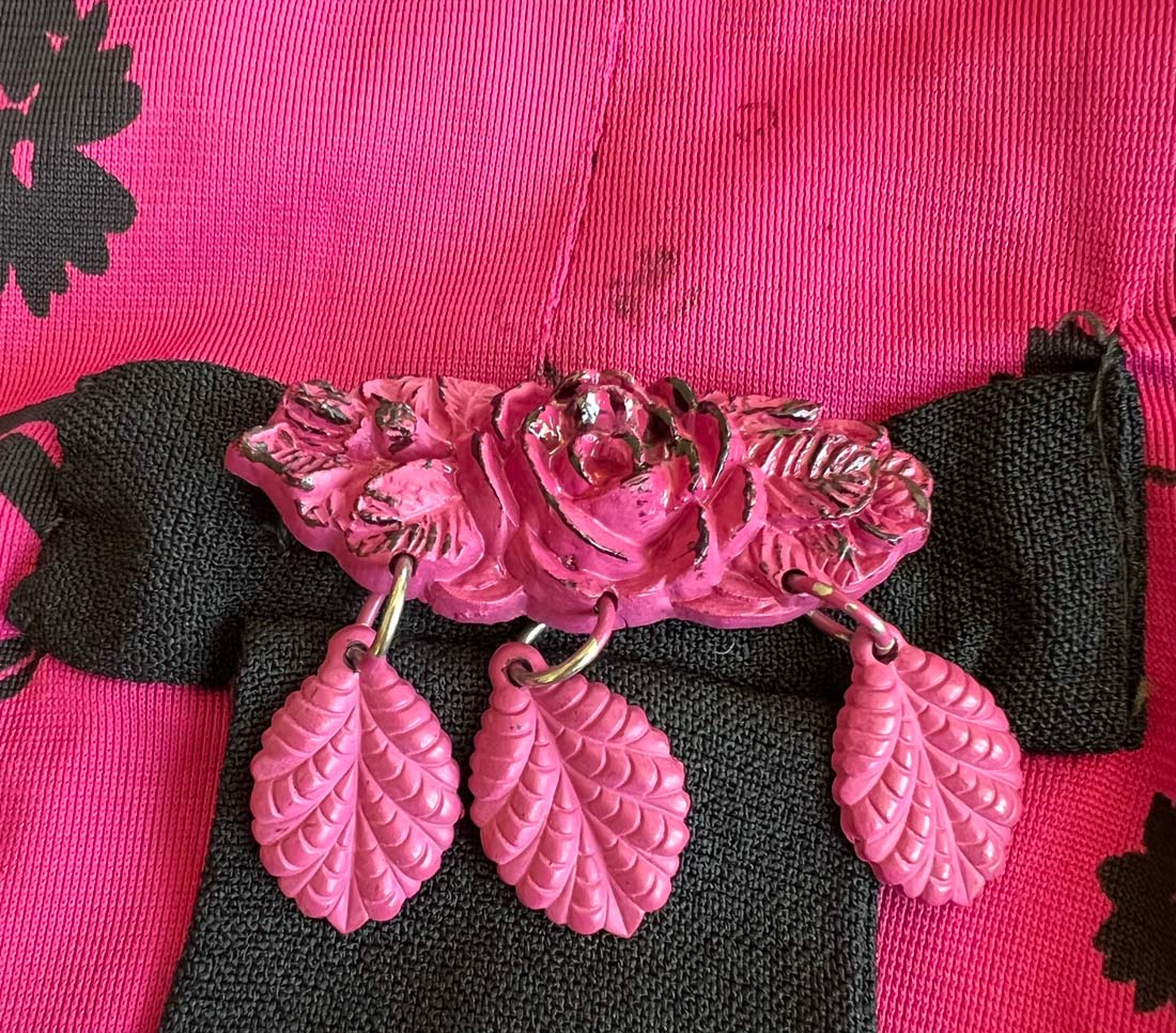 detail of dangly pink plastic pin