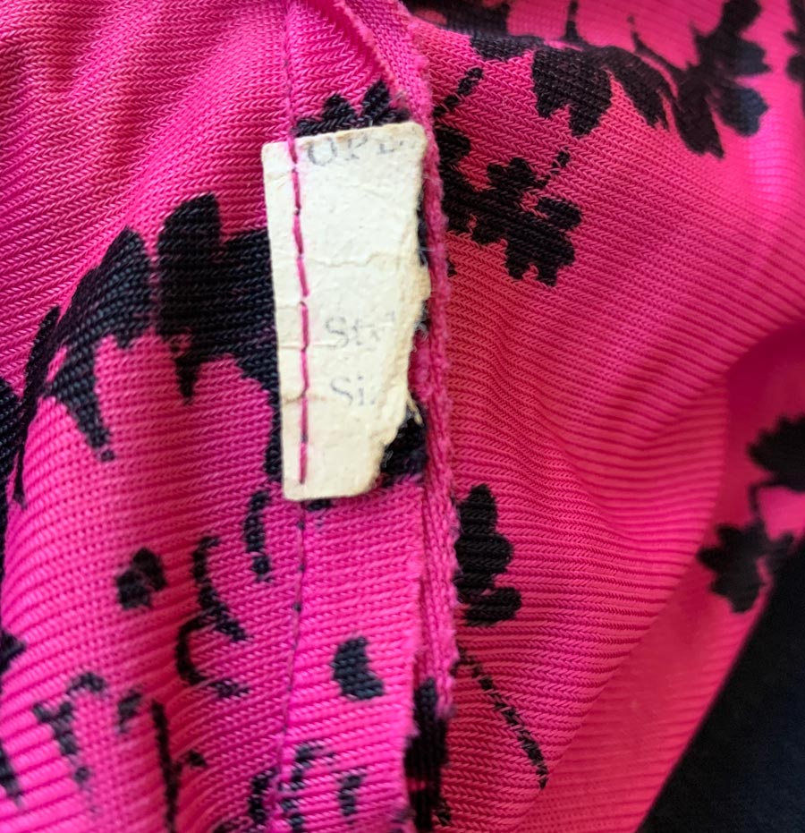 closeup view of maker's tag remnant on 40s pink print top