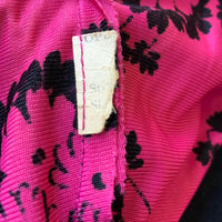 closeup view of maker's tag remnant on 40s pink print top