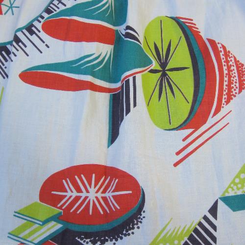 closeup of atomic kitsch print in tomato red, avocado green, and dark teal