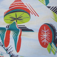 closeup of atomic kitsch print in tomato red, avocado green, and dark teal