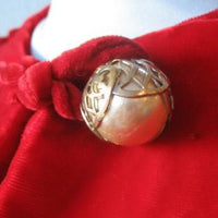 close up detail, decorative metallic ball button at neck of 40s red velvet coat