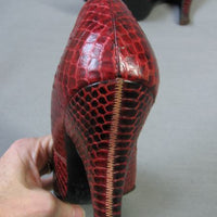 closeup view of red snakeskin heel from back 