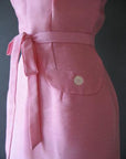 waist detail, sash and big button pocket flap of pink 50s day dress