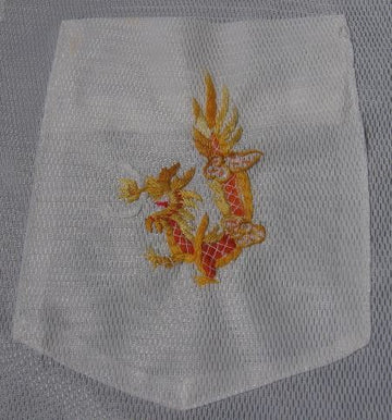 close up detail, embroidered dragon on pocket of 1960s vintage Asian tailored shirt