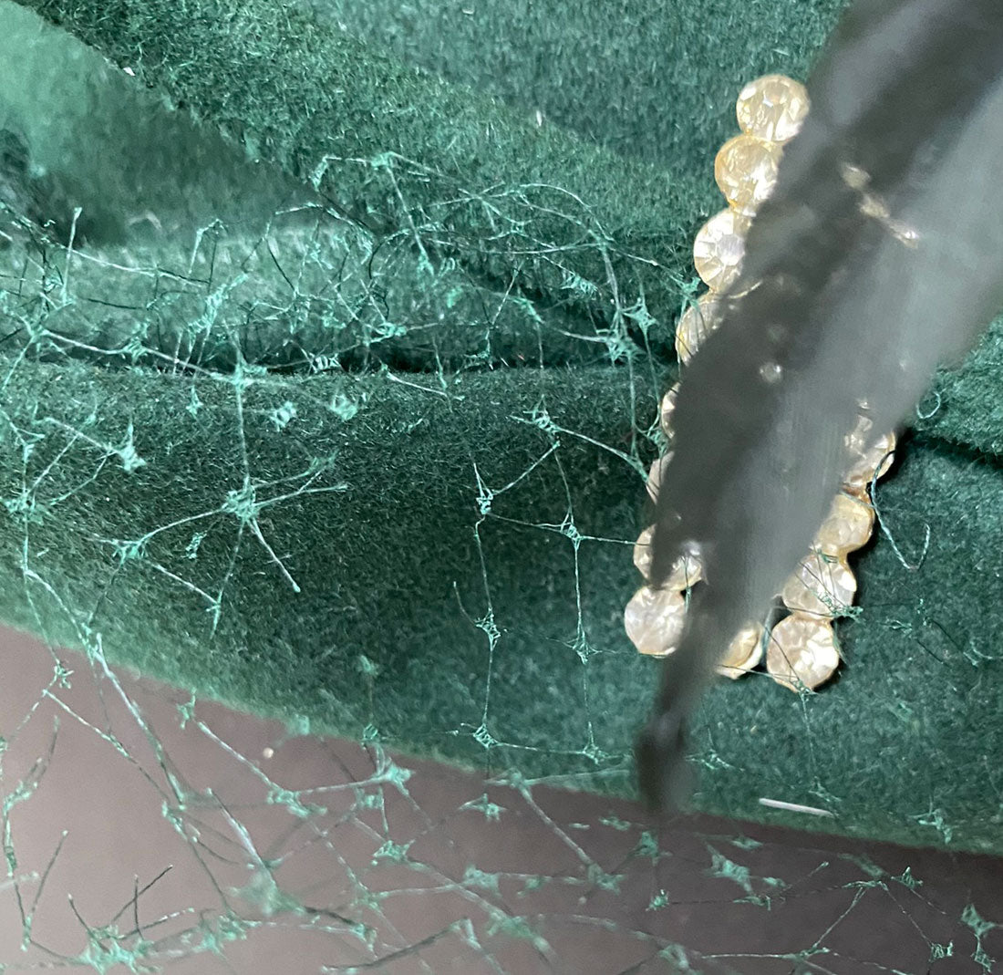 close up view of holes in netting of green cocktail hat