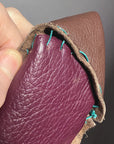 close up view, hand stitching nothing matches leather bag