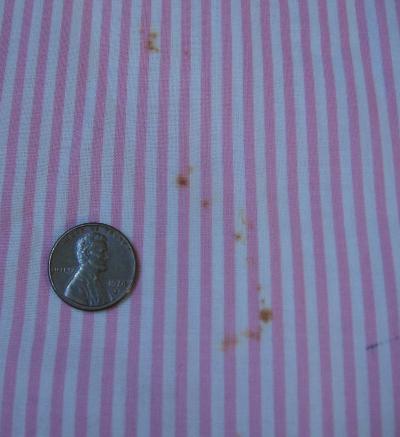 close up detail, tiny rust stains on 40s pink pinafore dress