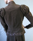 back view of jacket, with embellished peplum, puffed shoulders, and stand up collar