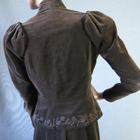 back view of jacket, with embellished peplum, puffed shoulders, and stand up collar